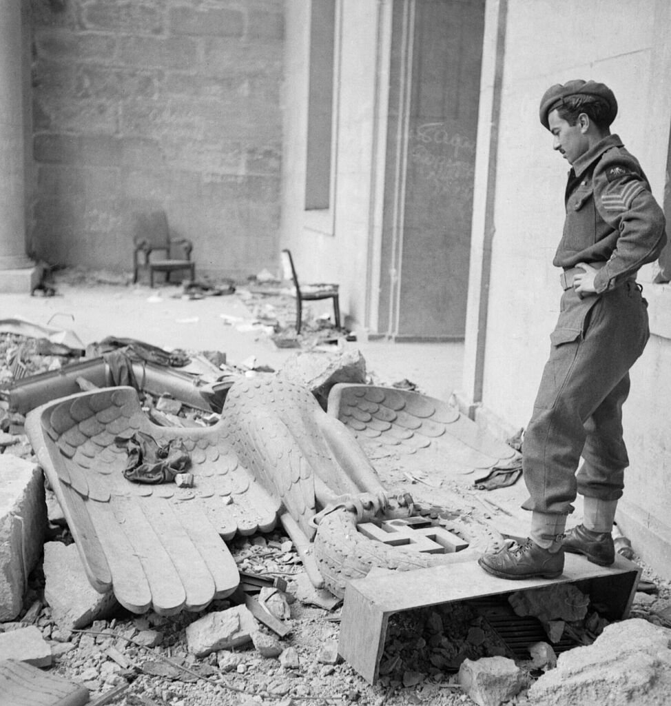 Un soldado británico observa el águila nazi caída entre las ruinas de la Cancillería del Reich, julio de 1945