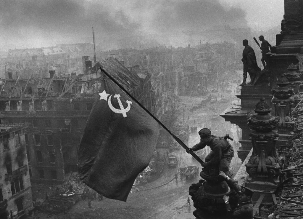 Soldados soviéticos izan la bandera roja sobre el Reichstag en ruinas, Berlín, mayo de 1945